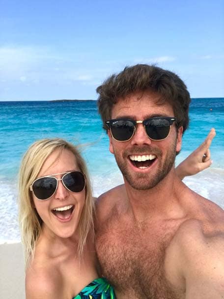 A couple on the beach wearing sunglasses