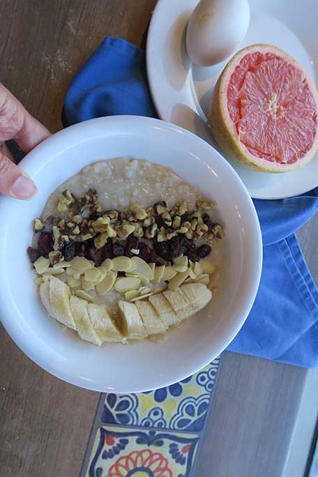 Oatmeal with banana, walnuts, almonds and raisins with an egg and half of a grapefruit on the side