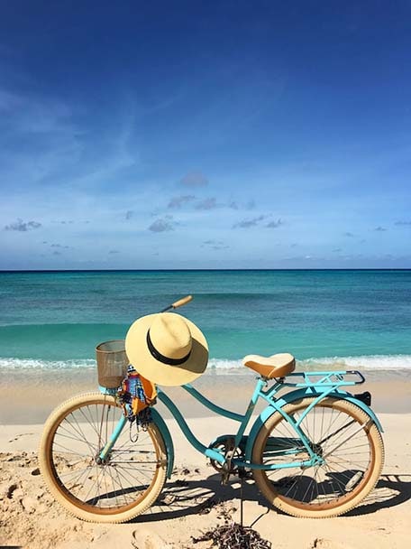 Blue bike with sun hat on handle bar on the beach in Grand Turk