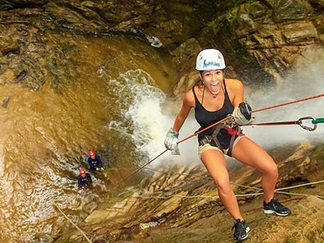 a woman rappelling through a waterfall in Puerto vallarta 