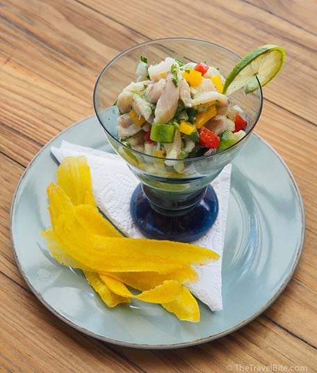 Mint and lime whitefish ceviche served in a clear blue glass