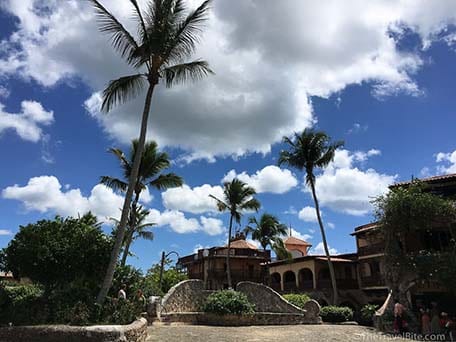 Altos de Chavon village in La Romana, Dominican Republic with palm trees and blue cloudy sky