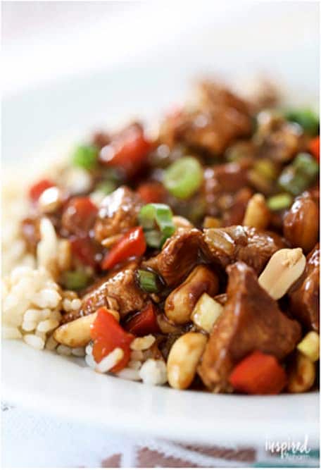 Kung Pao Chicken over white rice on a white plate