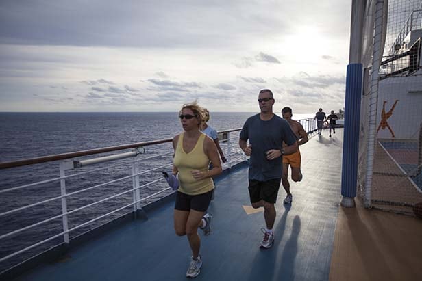 a group of people running on the track onboard a carnival cruise