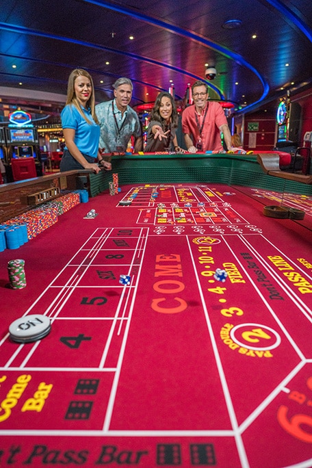 guests playing a game of craps at the onboard casino