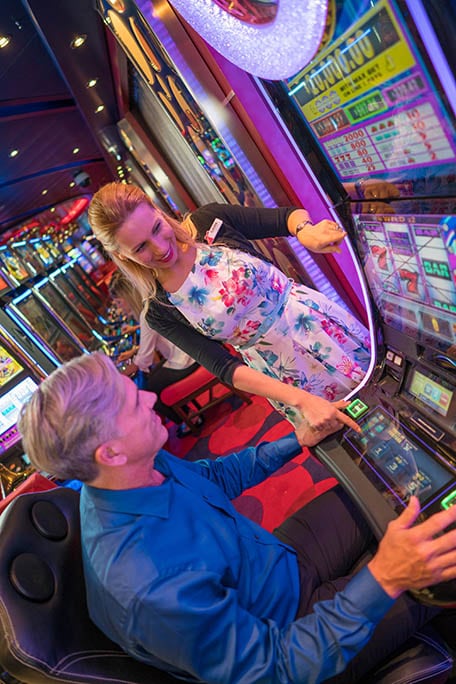 two guests playing the slot machines onboard