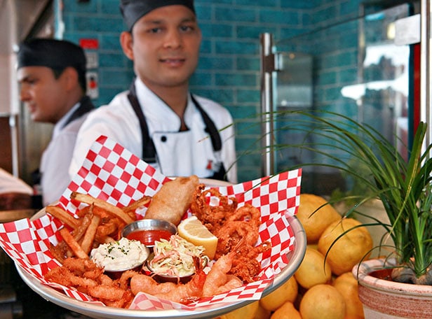 a waiter holding a seafood platter at seafood shack
