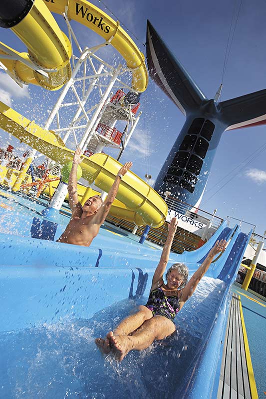 senior couple sliding down a water slide on a carnival cruise 