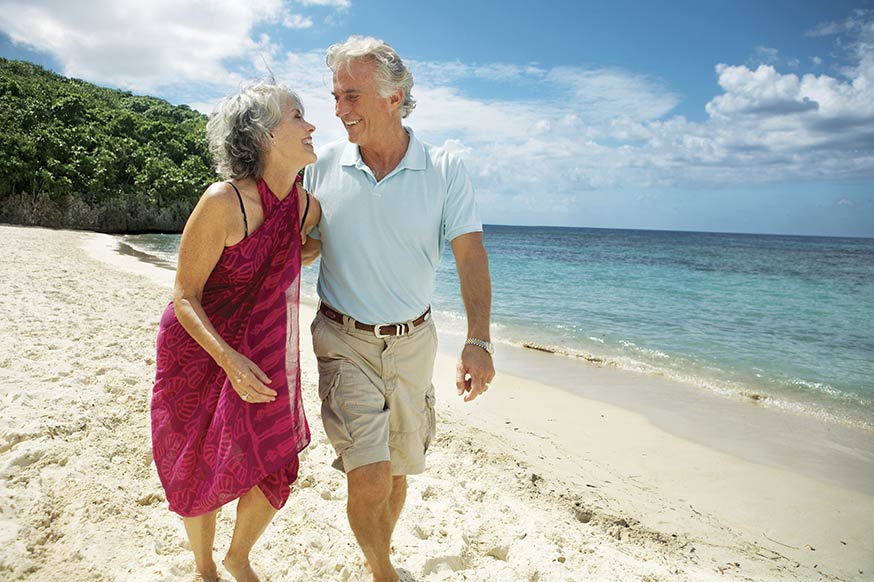 senior couple walking on the beach