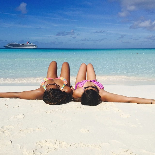 two women lying on a beach at half moon cay
