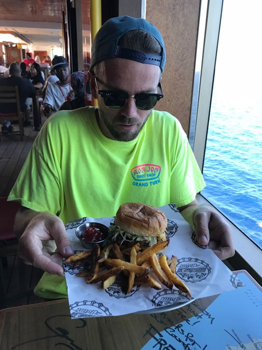 husband in bright green shirt eating burger