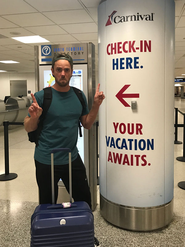 husband standing in front of cruise check-in