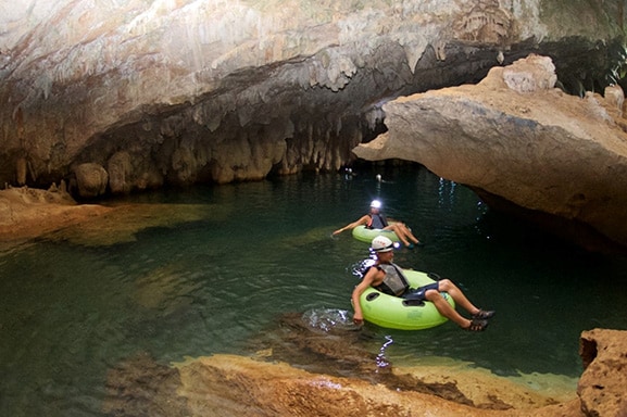 two people tubbing in a mayan ceremonial caves, crystal cave