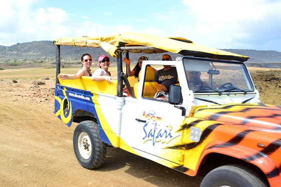 tourist taking a safari tour of the north coast of aruba on the back of a jeep