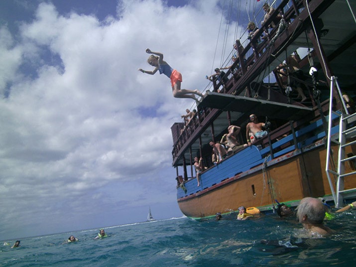 girl jumping off the pirate ship plank, into the water, as everyone watches