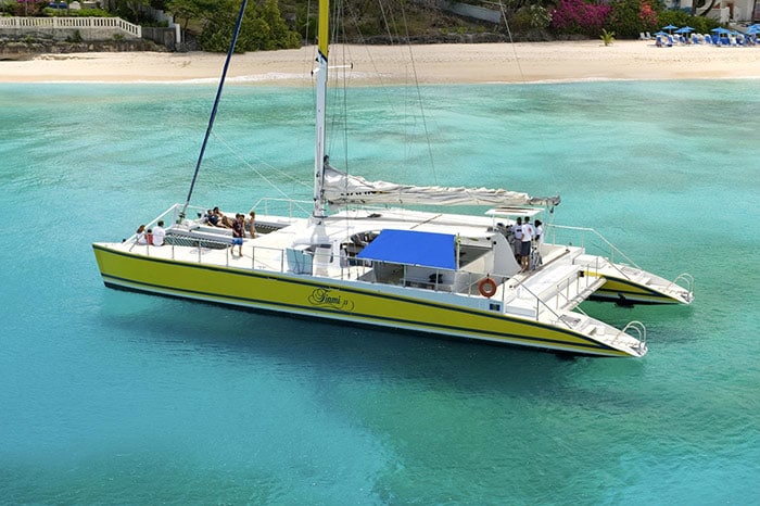 people on a yellow catamaran off the shore of barbados