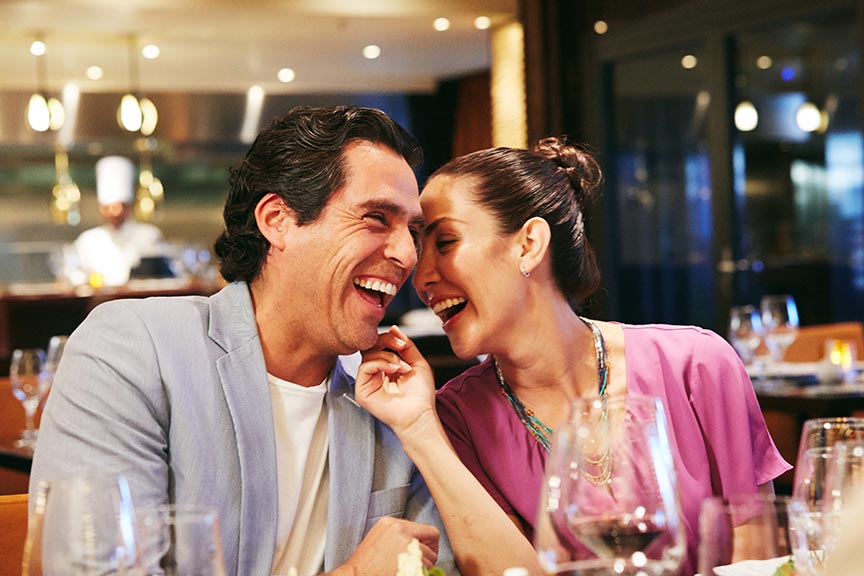 a couple laugh as they enjoy a romantic dinner at Fahrenheit 555 Steakhouse