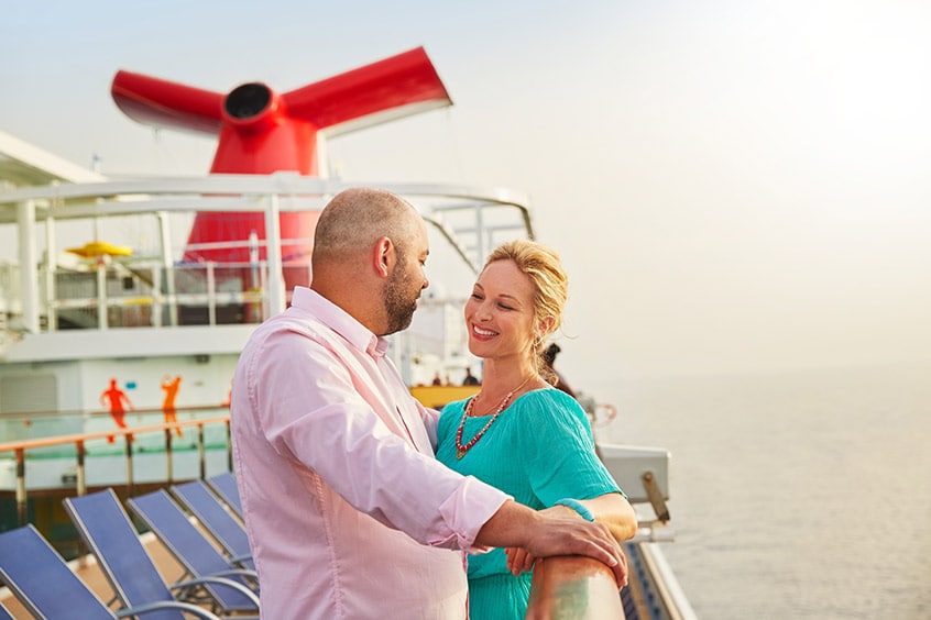 man and woman share a romantic stare onboard a carnival cruise