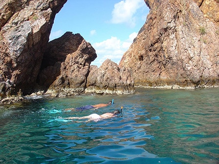 man and woman snorkeling near Treasure Point Caves