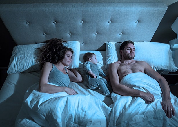 parents and baby getting a good night’s sleep