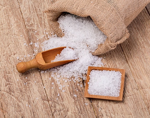 bag of sea salt on a wooden scoop and plate