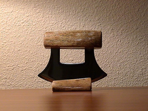 ulu knife from alaska on a wooden stand