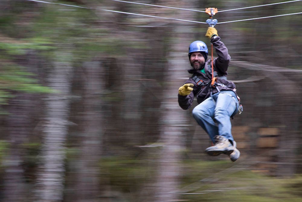 man zip lining in grizzly falls
