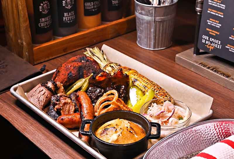 whole smoker dish with chicken, ribs, sausage and corn on the cob from guy’s pig and anchor