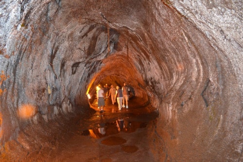 group of tourist exploring a lava tube in kilauea volcano hawaii