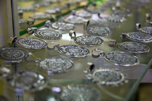 several mexican pendants made from taxco silver laid on a glass shelf