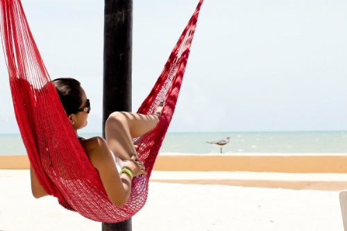 woman relaxing on a red hammock overseeing the beach in progreso 