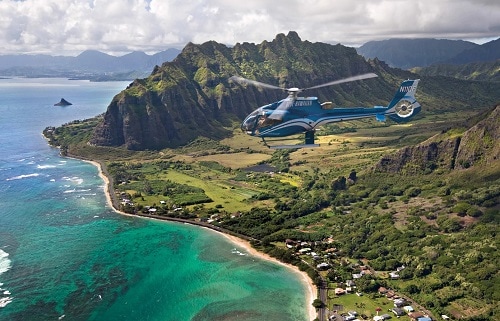 blue helicopter flying over the island of oahu from honolulu 