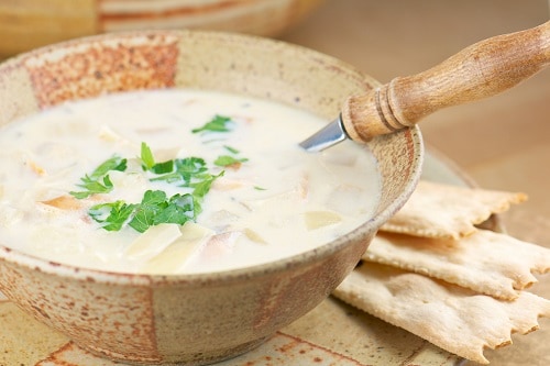 fish chowder served in a wooden bowl with crackers 