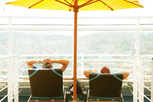 friends relaxing on beach chairs under a yellow umbrella in serenity, adults only retreat 