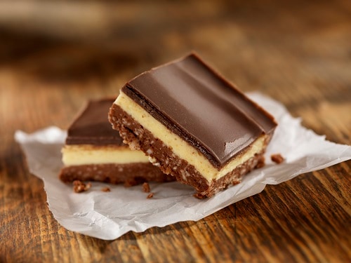 nanaimo bars made of yellow custard sandwiched between crackers and chocolate 