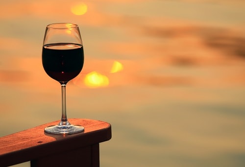 glass of wine from victoria on a wooden chair during the sunset 
