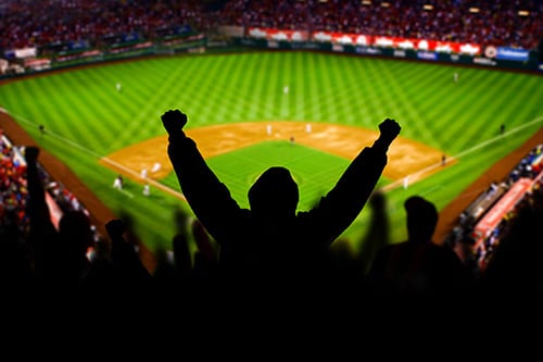 man raising his hands during a baseball game in a baltimore stadium 