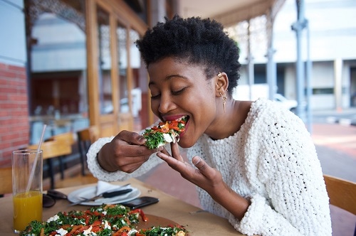 woman eating Italian pizza in downtown vancouver