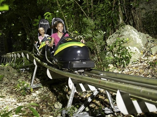 teenager and her younger sister going down a bobsled in montego bay, jamaica 