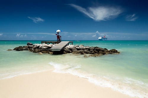 lifeguard on a wooden platform watching over the blue waters of a bahamas beach