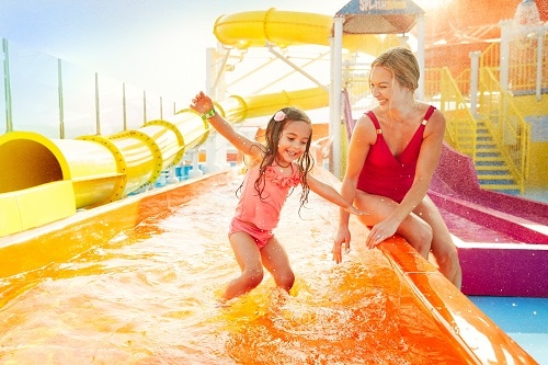girl playing in waterworks with her mom on a carnival cruise ship 