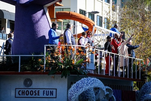 crew members singing and waving as the carnival panorama float passes by during the rose parade