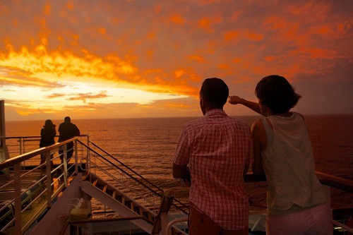 couple admiring the sunset onboard a carnival cruise ship