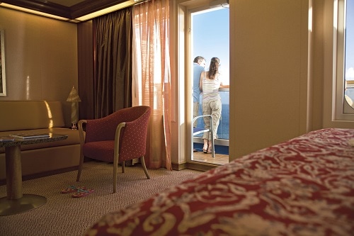 couple enjoying their stateroom balcony on a carnival cruise