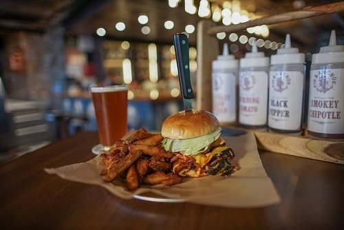 delicious guy's burger served with fries and a beer
