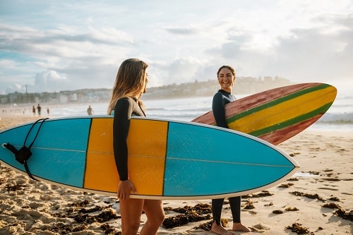 friends holding surf boards at a hawaiian beach