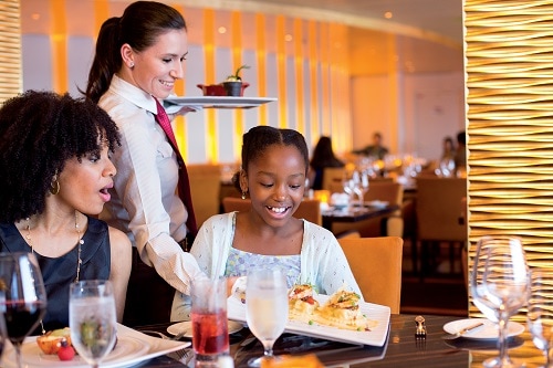 server delivering a delicious meal on board carnival paradise