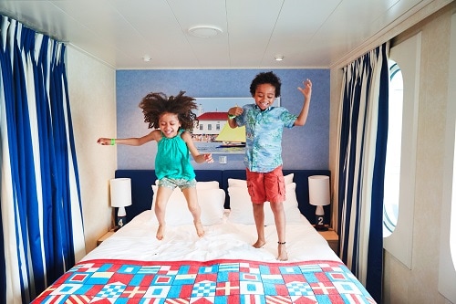 happy children bouncing up and down the stateroom bed