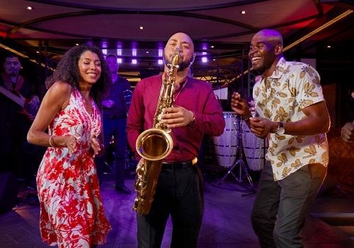 couple at carnival’s nightclub dancing with a saxophone player