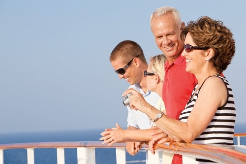 senior couple and their family standing by the ship railing